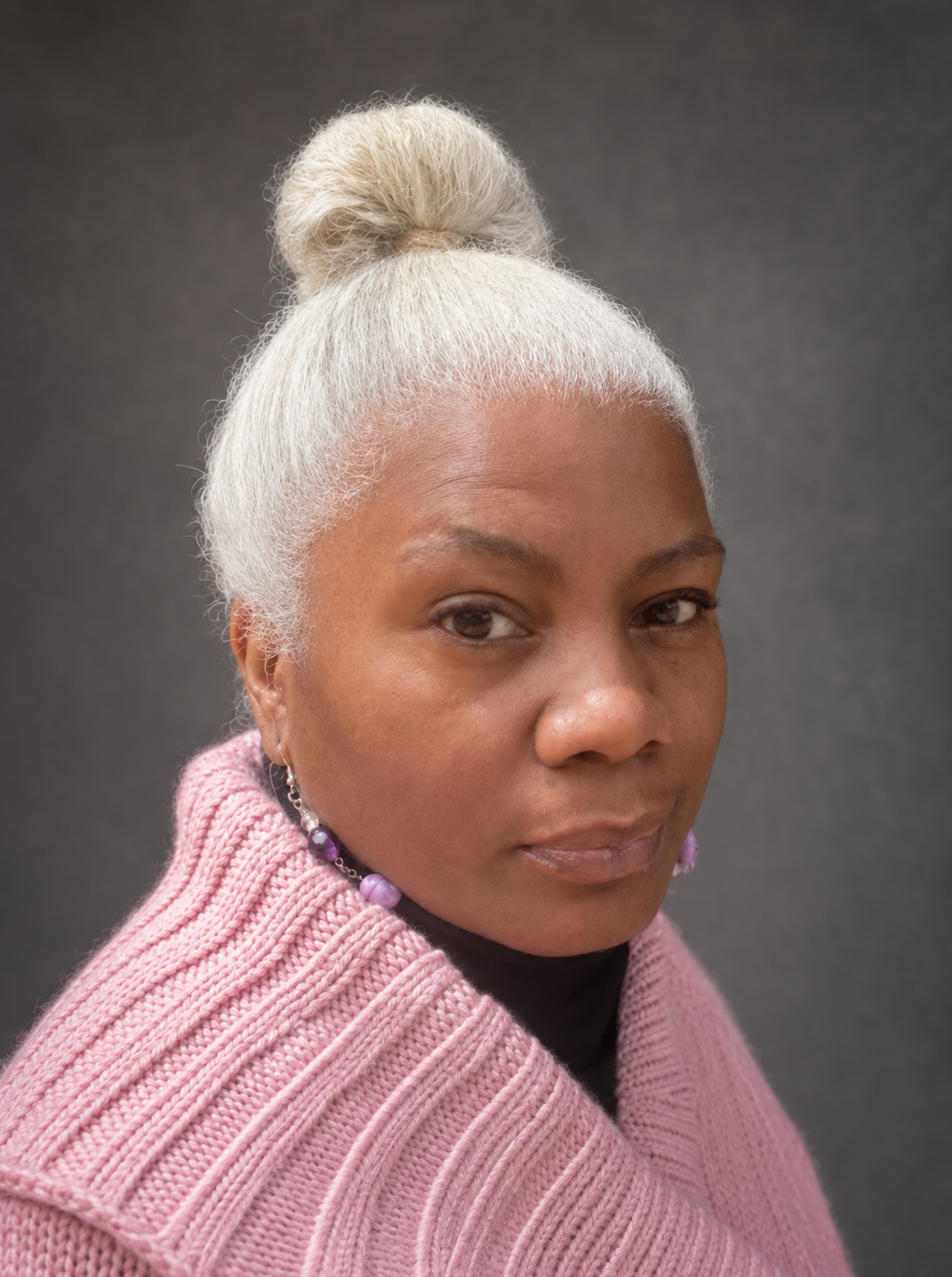 Professional portrait of Cariol Horne with a silver hair bun