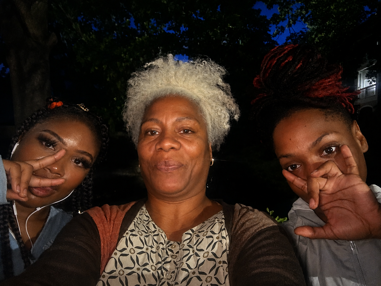 Cariol Horne spending time with two young women at a nighttime community gathering